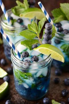 two mason jars filled with blueberries and limeade, topped with minty straws