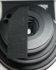 a close up view of a camera with its lens cap on it's side