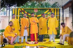 a group of men standing next to each other in front of a cake