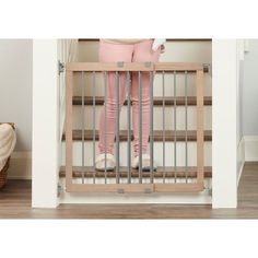 a woman standing in front of a baby gate