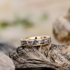 two wedding rings sitting on top of a rock