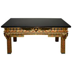 a black table with gold and red designs on the top, in front of a white background