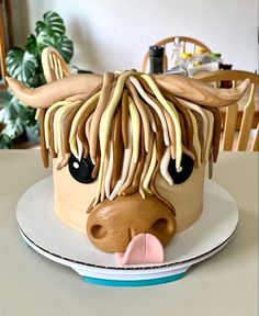 a cake decorated to look like a cow's head with long hair and black eyes