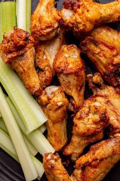 chicken wings and celery on a black plate