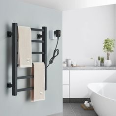 an electric towel warmer hangs on the wall next to a bathtub