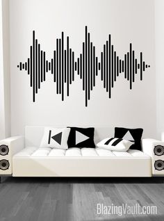 a white couch sitting in front of a wall with black and white sound waves on it