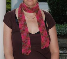 a woman wearing a pink and green knitted scarf with a smile on her face