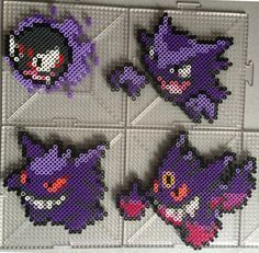 four pixel art pieces are displayed on a tile wall in the shape of pokemon's heads