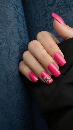 a woman's hand with bright pink nail polish