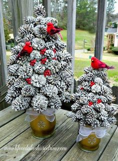 two pine cones are decorated with red and white decorations