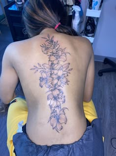 the back of a woman's body with flowers on it