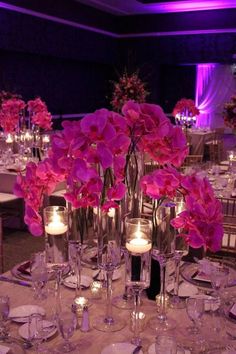 the table is set up with candles and pink flowers in vases on each side