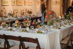 a long table is set with flowers and plates