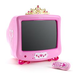 a pink computer with a crown on top and a remote control next to the monitor