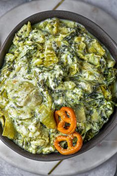 a bowl filled with spinach and cheese on top of a plate