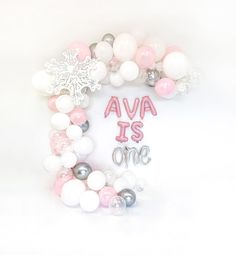 a pink and white balloon garland with the words ava is one