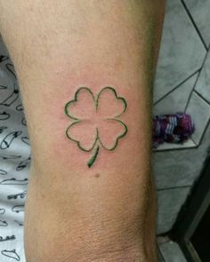 a four leaf clover tattoo on the arm