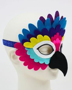 a white mannequin head wearing a colorful mask