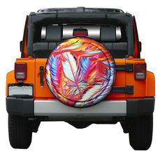 an orange jeep with colorful leaves painted on it's front tire cover, is shown