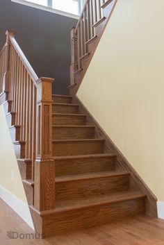 a wooden staircase leading up to a second story window in a new home with hardwood floors and white walls