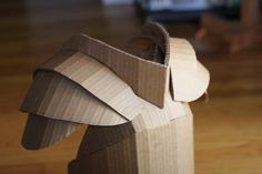 an elephant made out of cardboard sitting on top of a hard wood floor