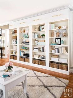 a living room filled with lots of white bookshelves