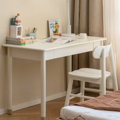 a white desk with a chair next to it in front of a wall and window