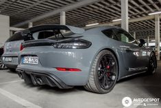 two grey sports cars parked next to each other in a parking garage