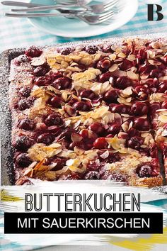 a dessert with berries and almonds on top is shown in front of the words butterkuchen mit sauerkrschen