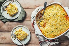 a casserole dish with corn on the side and two plates next to it