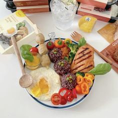 a plate with eggs, meat and vegetables on it next to some other food items