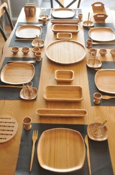 a wooden table topped with lots of plates and bowls