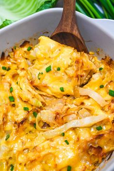 a casserole dish with cheese and onions in a white bowl on a wooden spoon