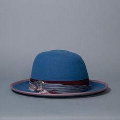 Western weight fedora with sculpted crown and upturned brim. Trimmed with mix-match grosgrain band and bow, silk sari ribbon and vintage silver buckle. Brim edge is bound with mauve grosgrain. Materials: Ethically sourced 160 g rabbit fur felt, Grosgrain, Silk, Metal Style: Western Fedora Measurements: Crown height at center front 5 in (13 cm) Brim 3 in (7.5 cm) Hat Box: 16 in How to Wear: Classic fit Ready to ship in a size 22.5 in / 57 cm / men's 7-1/8 with slightly-wider oval profile. One of Sari Ribbon, Crown Heights, Hat Box, Silk Sari, Rabbit Fur, Metal Style, Slate Blue, Mix Match, Vintage Silver