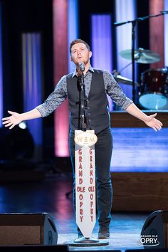 a man standing on stage with his arms outstretched