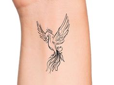 a small bird tattoo on the side of a woman's right arm and leg