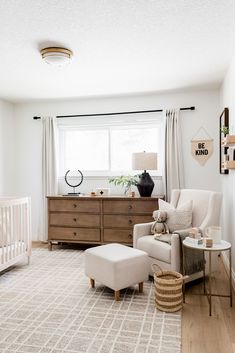 a baby's room with a crib, dresser and chair