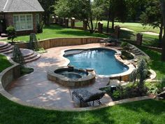 a backyard with a swimming pool surrounded by landscaping