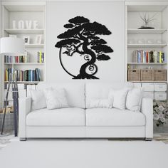 a living room with a white couch and black tree wall decal