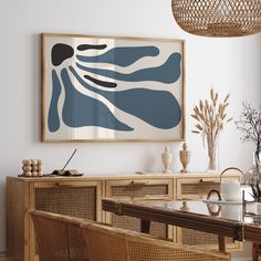 a painting hanging on the wall above a dining room table with chairs and vases