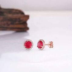 Looking to make a breathtaking impact on your outfit? Look no further than our iconic Jia ruby earrings. Made from glistening gold materials, each earring is finished with a 0.75-carat ruby gemstone as the centerpiece; meanwhile, we’ve completed the design with CZ crystals around the edge for a little extra luxury and class overall. ✦ DETAILS ✦ ✧ Handcrafted ✧ 0.75 Carat center stone ✧ Ruby and cz crystals ✧ 8mm (about 6/8 inch round) ✧ Sterling Silver 925 or 14K Rose Gold Vermeil or 14K Gold Vermeil. Fine Jewelry Ruby Diamond Earrings, Ruby Diamond Earrings Fine Jewelry, Ruby Gemstone Diamond Earrings In Fine Jewelry Style, Ruby Diamond Earrings In Fine Jewelry Style, Red Synthetic Ruby Earrings, Ruby Diamond Earrings For Anniversary, Anniversary Ruby Diamond Earrings, Red Diamond Earrings Fine Jewelry, Fine Jewelry Red Diamond Earrings