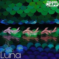 three small dragon figurines sitting on top of a green and blue background with the words lunaa