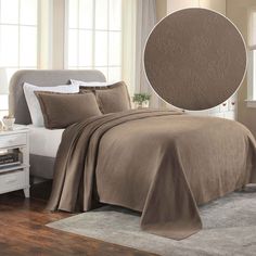 a bed with a brown comforter and pillows