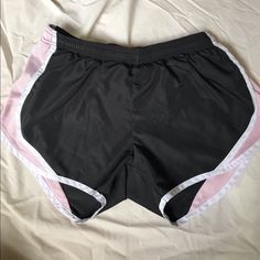 a pair of black and pink shorts laying on top of a bed