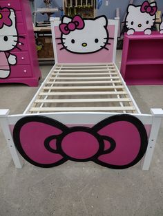 a bed with hello kitty head on the top and bottom rails, in a room filled with pink furniture