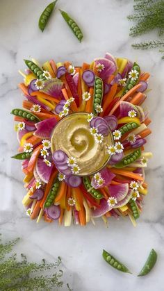 an arrangement of carrots, radishes and other vegetables on a marble surface