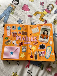 an open children's book with stickers and pictures on the cover, sitting on a bed