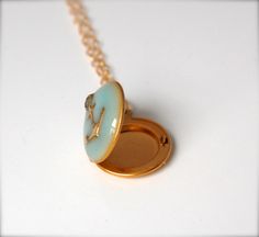 "*IMPORTANT SHIPPING INFORMATION: Verabel will be out of the studio during the month of June 2021. We will still be accepting orders during this time, but please note they will not ship until after July 1, 2021. xo A delicate locket features a brass anchor against a light turquoise enamel. The locket opens to hold two tiny keepsake photographs. Send your pictures through the Etsy conversation feature after purchase and we'll place them for you. ~Locket measures 1/2\" ~18\" brass chain" Turquoise Locket For Wedding Jewelry, Turquoise Locket Jewelry For Wedding, Turquoise Wedding Locket Jewelry, Blue Brass Jewelry For Wedding, Blue Enamel Locket Jewelry, Turquoise Round Locket Jewelry, Round Turquoise Locket Jewelry, Blue Brass Jewelry With Vintage Charm, Blue Vintage Charm Jewelry Gift