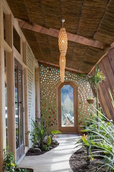 the inside of a house with wooden walls and plants on either side of the door