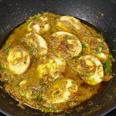 some food is cooking in a skillet on the stove top, ready to be eaten